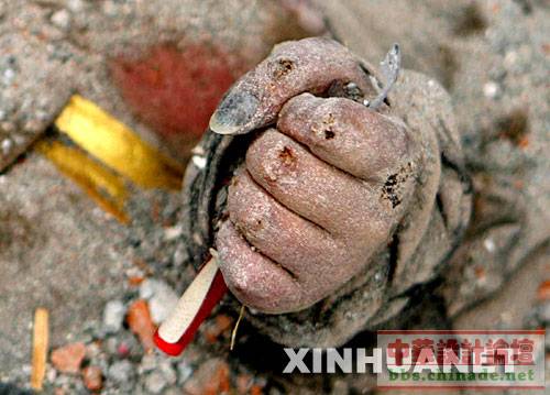 这是5月16日晚拍摄的四川省绵竹市汉旺镇东汽中学发掘现场的一幕――一名死难学生手里紧紧攥着一支笔。
